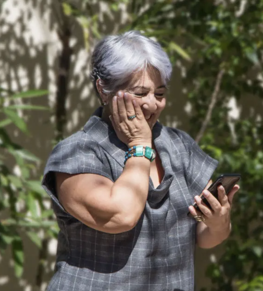 Older woman amazed and delighted looking at her phone